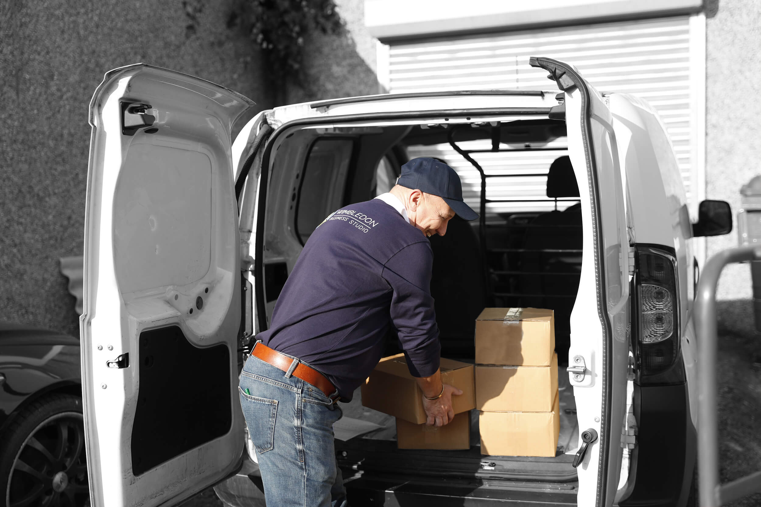 a man unloading boxes at the back of a van