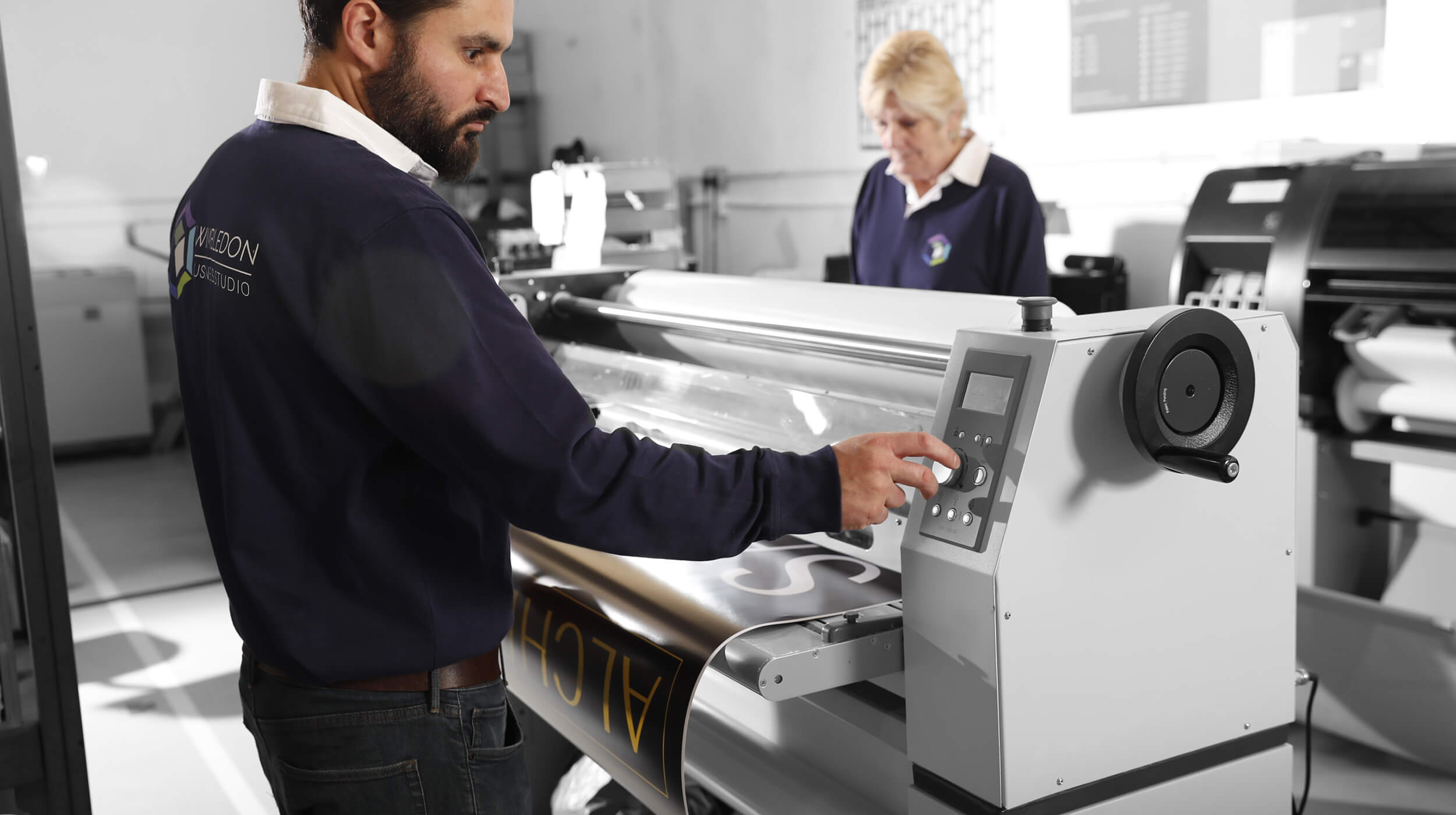 A man and woman operating a printing machine